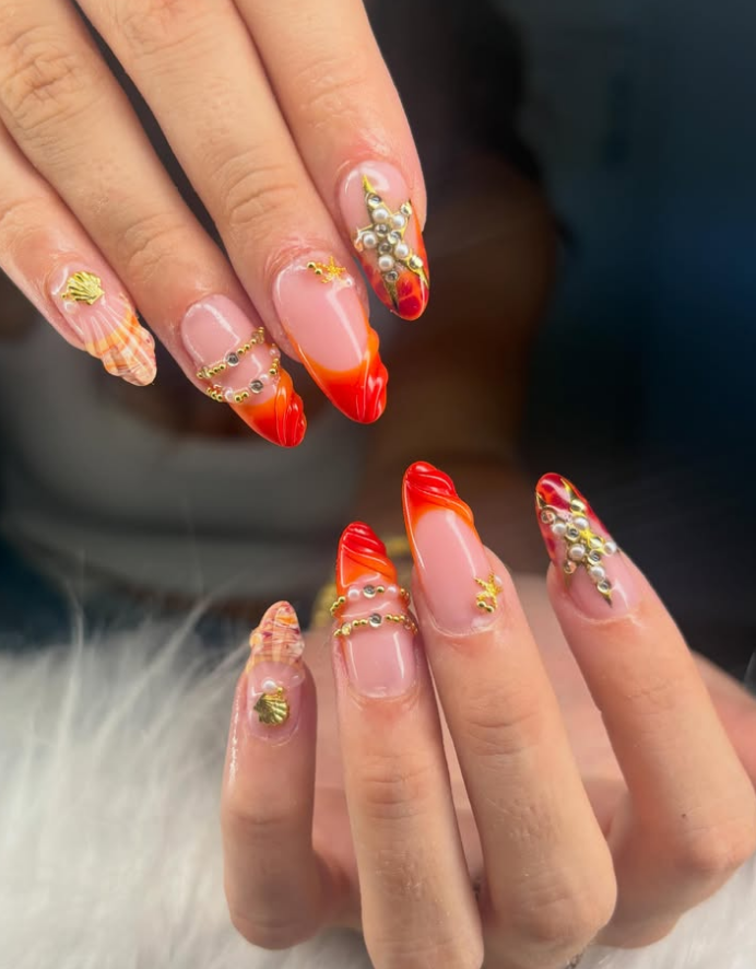 Nail art rouge et orange avec détails dorés